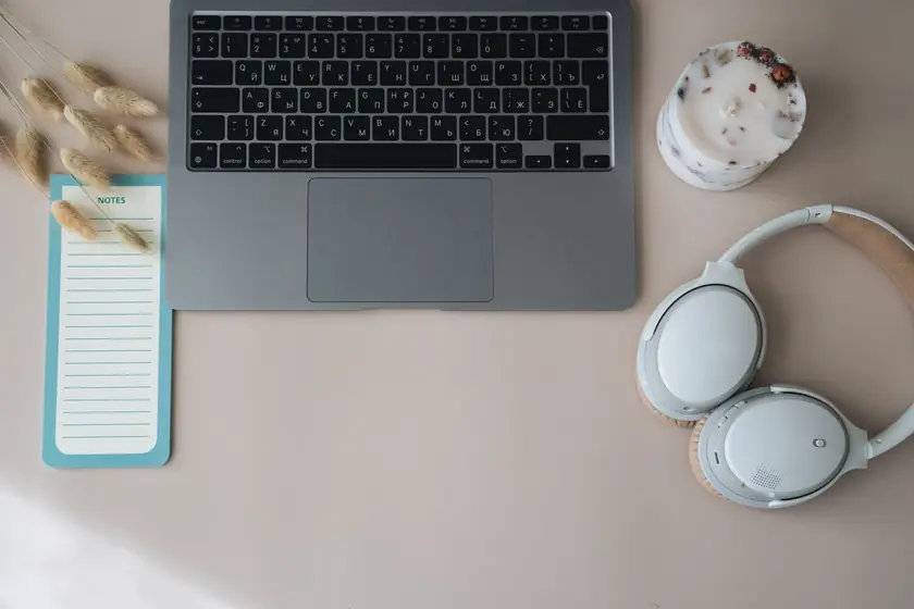 Real photograph of a contemporary laptop and desk headphones